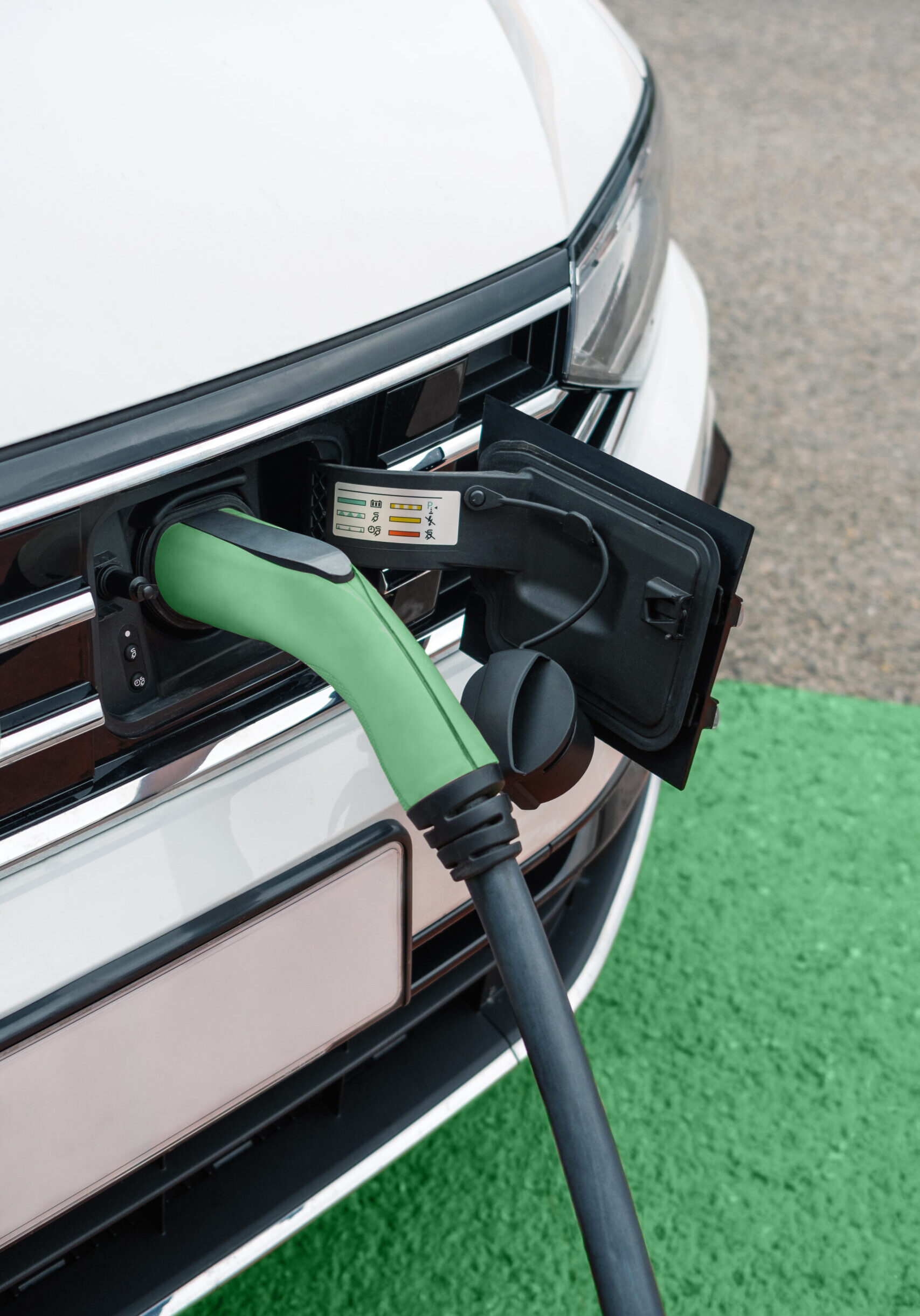 Detail of socket plugged into electric car outdoors